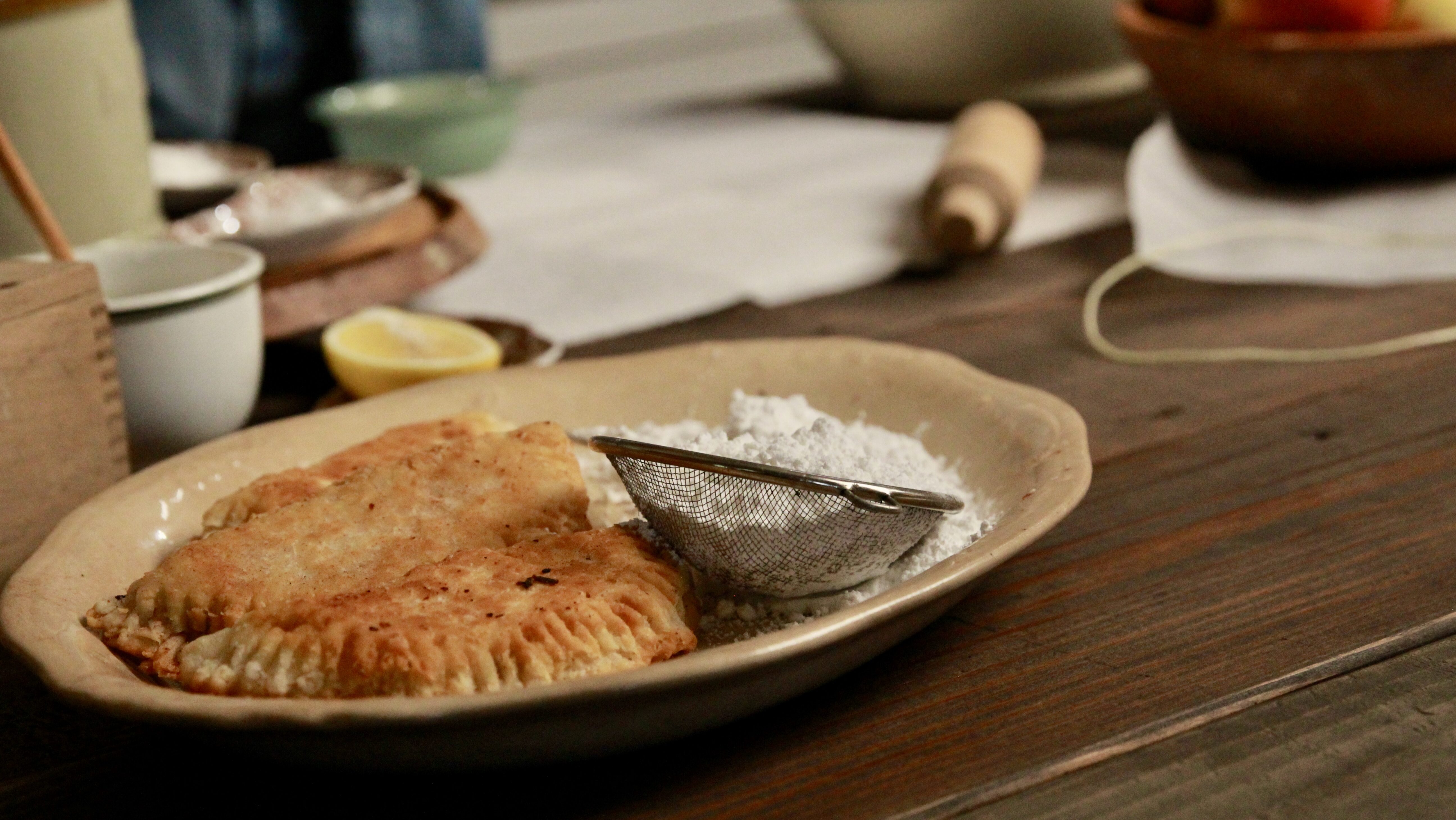 Plated fried apple hand pies on a rustic kitchen counter