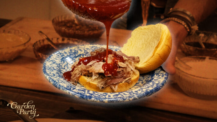 Trace drizzles BBQ sauce over BBQ meat on a hamburger bun.