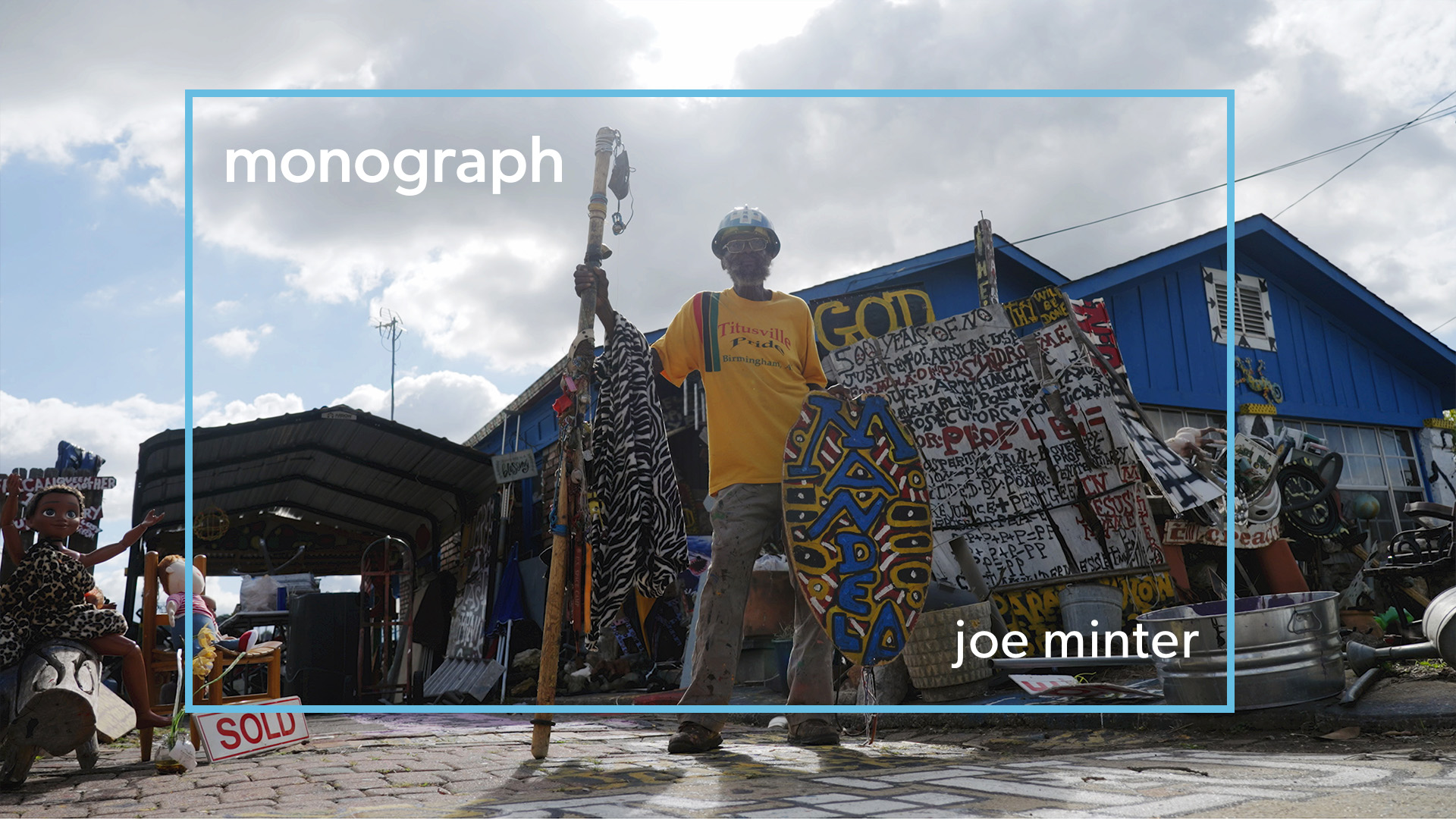 Photo of folk artist Joe Minter surrounded by his art